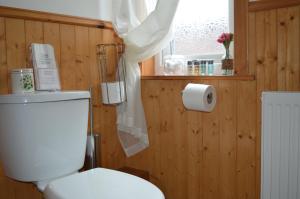 bagno con servizi igienici bianchi e finestra di Strathview Lodge a Dornoch