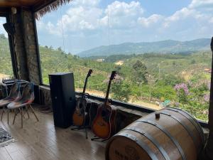 a group of guitars sitting in a room with a view at Giăng's House Farmstay & Glamping in Bao Loc