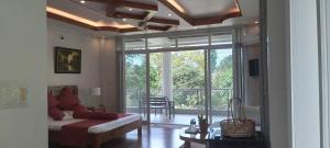 a living room with a couch and a large window at Camiguin Lanzones Resort in Mambajao