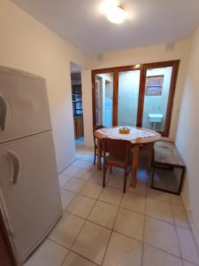 a dining room with a table and a refrigerator at Hospedaje Cumbres Mendocinas - El Diamante in San Rafael