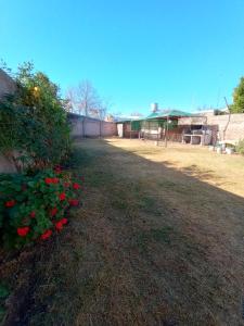 un patio con flores rojas y un edificio en El Diamante en San Rafael