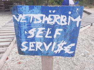 un signo azul que dice que el servicio séptico semanal en él en Lost Paradise Camping Beach & Bar en Himare