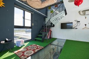 ein Wohnzimmer mit grünem Boden und einer Treppe in der Unterkunft 綠寶石休閒農場 其他房型請加Line in Guilin