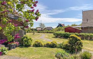 a yard with a fence and a garden with flowers at Stunning Apartment In Friedrichskoog Spitze With Kitchen in Friedrichskoog-Spitze