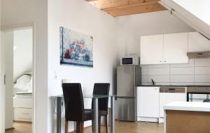 基爾的住宿－Nice Apartment In Kiel With Wifi And 1 Bedrooms，厨房配有桌椅和冰箱。