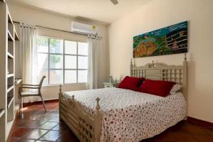 een slaapkamer met een bed, een stoel en een raam bij JUNTO AL MAR Y EL MANGLAR in Cartagena