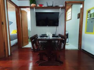 a dining room with a table and a flat screen tv at Terê c/Lazer completo-RelaxTerêMontainHouse in Teresópolis