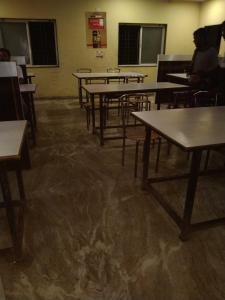 une salle de classe avec des tables et des chaises dans l'établissement SPOT ON Akshay Graden Lodge, à Pune