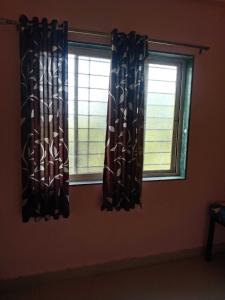 - deux fenêtres dans une chambre avec rideaux dans l'établissement SPOT ON Akshay Graden Lodge, à Pune