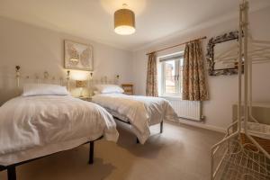 une chambre avec deux lits et une fenêtre dans l'établissement Ken Hill Cottage, à Snettisham