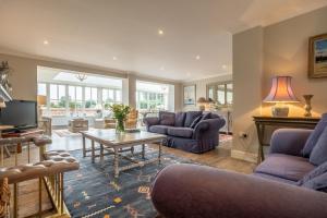 - un salon doté d'un mobilier violet et d'une table dans l'établissement Field Piece Cottage, à Burnham Market