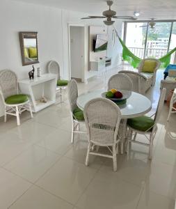 comedor con mesa blanca y sillas en Apartamento en el Rodadero, Confortable y amplio, con vista al mar, a 80mt de la playa, DELAMAR Apartmet, en Santa Marta