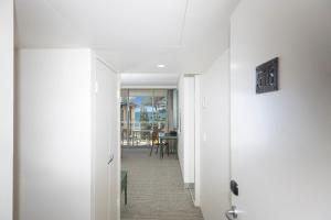 a hallway with a white door and a dining room at The Sebel Sydney Manly Beach in Sydney