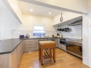 uma grande cozinha com electrodomésticos em aço inoxidável e pisos em madeira em River View Cottage em Maclean