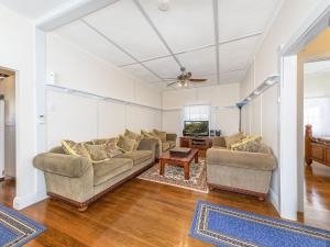 uma sala de estar com dois sofás e uma televisão em River View Cottage em Maclean