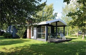 a pavilion with a table and chairs in a yard at Holiday Home Strandkrogen Ix in Dronningmølle