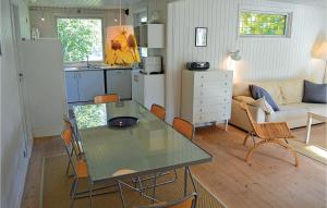a kitchen and living room with a table and a couch at Holiday Home Strandkrogen Ix in Dronningmølle