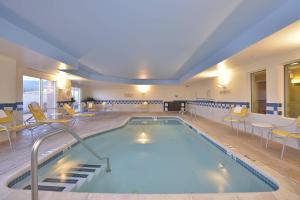una gran piscina en un hotel con sillas y mesas en Fairfield Inn and Suites by Marriott Williamsport, en Williamsport