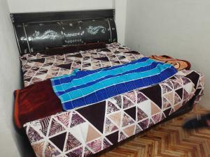 a bed with a quilt on it in a room at OYO Chaudhry Hotel in Hāthras