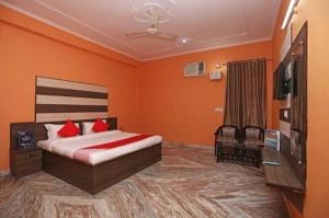 a bedroom with a bed and a flat screen tv at OYO Chaudhry Hotel in Hāthras