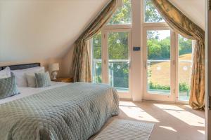 a bedroom with a bed and a large window at Luxurious 3 Bedroom New England Style Villa - Trewhiddle V8 in St Austell