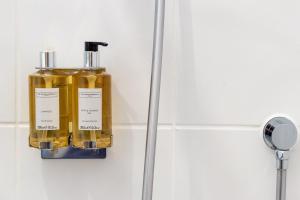 a bottle of oil hanging on a wall in a bathroom at Luxurious 3 Bedroom New England Style Villa - Trewhiddle V8 in St Austell +32 photos