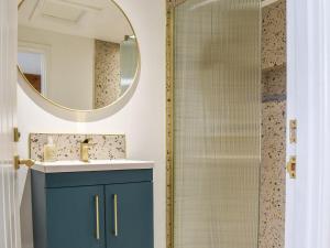 a bathroom with a blue cabinet and a shower at Barn Owls Nest-uk39432 in Dronfield