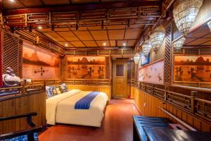 a bedroom with a bed and paintings on the walls at Li River Gallery Lodge in Yangshuo