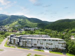 un immeuble d'appartements avec des montagnes en arrière-plan dans l'établissement Setsu Niseko, à Niseko