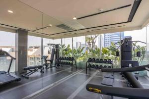 un gimnasio con equipo cardiovascular en un edificio con ventanas en 2 Bedroom Luxury Apartment 3 min walk from BTS Ekkamai en Bangkok