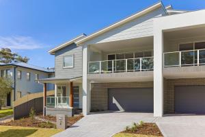 a house with a garage in front of it at Comfort Luxury and Surrounded by Popular Beaches in Boat Harbour