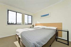 a bedroom with a bed with a table and a window at Close to Little Beach and Shoal Bay Beach in Nelson Bay
