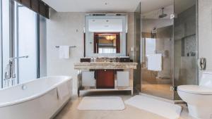 a bathroom with a tub and a sink and a toilet at Shanghai Marriott Marquis City Centre in Shanghai