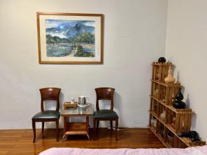 三義鄉的住宿－馨雅民宿，一间设有两把椅子和一张桌子的房间,一张图片