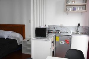 a small kitchen with a sink and a small refrigerator at Mini Suites Cuarto Piso Alkimya in Loja