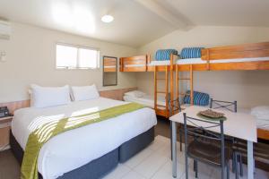 1 dormitorio con 2 literas y escritorio en Lake Taupo Holiday Resort, en Taupo