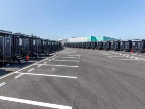 een lege parkeerplaats met veel containers bij HOTEL R9 The Yard Izumi in Izumi