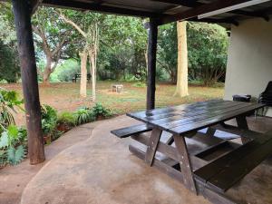a wooden picnic table sitting on a patio at Mkumbi Farm Cottage in Hluhluwe