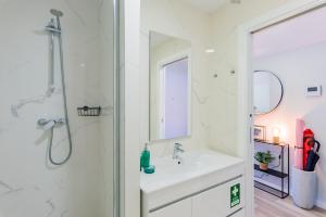 アヴェイロにあるTeatro à Vista - No coração do centro de Aveiroの洗面台とシャワー付きの白いバスルーム +7枚の写真