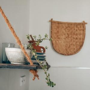 a shelf with a bowl and a basket on a wall at Salty Alchemy in Arugam Bay