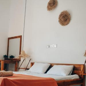 um quarto com uma cama e duas grinaldas na parede em Salty Alchemy em Arugam Bay
