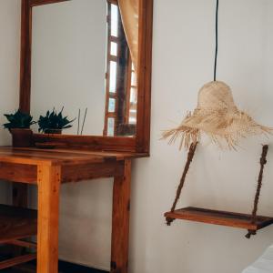 a mirror and a wooden table with a swing at Salty Alchemy in Arugam Bay