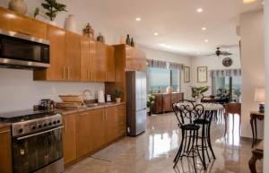 a large kitchen with wooden cabinets and a dining room at Capitan Boutique Resort in Puerto Nuevo