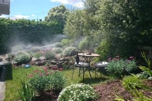 a garden with a table and chairs in the grass at Comfy fully contained 2 bedroom home in New Town