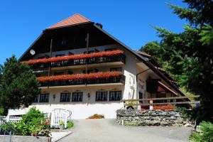 ein Gebäude mit roten Blumen auf der Seite in der Unterkunft Gasthof Hotel Engel in Simonswald