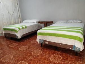 duas camas sentadas uma ao lado da outra num quarto em Casa Elenita em San Juan La Laguna