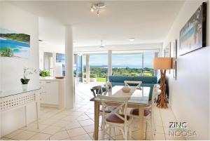 a kitchen and dining room with a table and chairs at Crest Premium View Apartment 19 in Noosa Heads