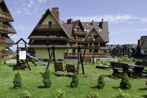 a large house with a playground in front of it at Apartament Pardałówka Prestige in Zakopane