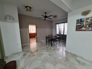 een woonkamer met een plafondventilator en een tafel bij Al-Bayt Homestay in Ayer Keroh