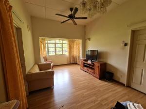 a living room with a couch and a flat screen tv at Al-Bayt Homestay in Ayer Keroh